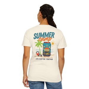 A person faces away, wearing a Printify BODE Summer Camp T-Shirt 2026—Unisex Comfort Colors 1717—in white, featuring a beach scene and "LIFE IS BETTER TOGETHER" text. Double-needle stitching adds durability.