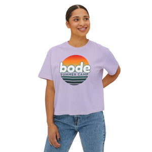 A person wears a Printify 2026 Bode Summer Bootcamp Cali Sunset Logo Crop T-Shirt (3023CL) in light purple ring-spun cotton, paired with blue jeans.