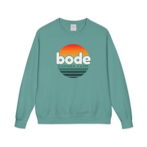 The 2026 Bode Summer Bootcamp Crewneck Sweatshirt (GDH400) by Printify features a teal vintage-washed fleece, an extra soft feel, and a “bode SUMMER CAMP” logo with an orange-yellow sunset graphic above black waves.