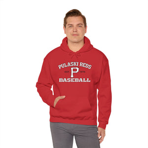 A man wears the Printify Pulaski Reds Baseball Est. 1978 Unisex Heavy Blend™ Hooded Sweatshirt, featuring the classic front print, against a plain white background.