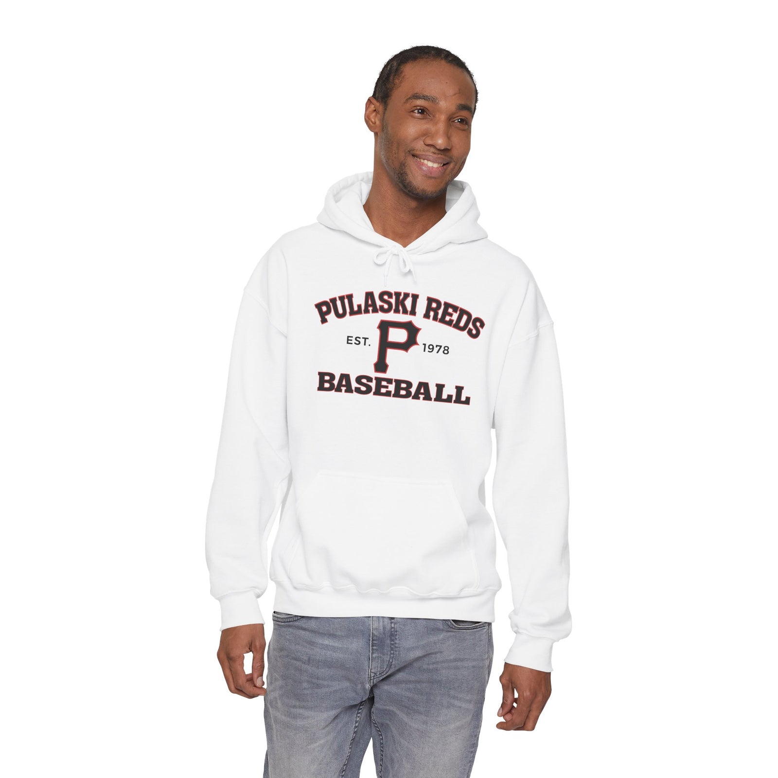 A man smiles in a Printify P Reds Baseball Est. 1978 Unisex Heavy Blend™ Hooded Sweatshirt, featuring "Pulaski Reds Baseball Est. 1978" on the front, standing against a white background.