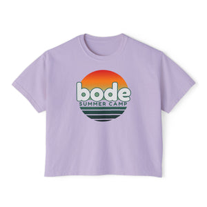The Printify 2026 Bode Summer Bootcamp Cali Sunset Logo Crop T-Shirt (3023CL) is a lavender, ultra-soft ring-spun cotton tee with a boxy cropped fit and "bode SUMMER CAMP" over a retro sunset graphic.