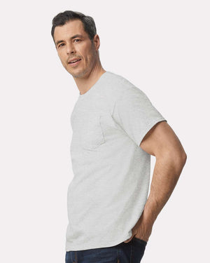 Man wearing a Gildan 2300 Unisex Ultra Cotton® Pocket T-Shirt (Pack of 36), custom screen printed logo included, paired with dark jeans and standing against a plain light background.