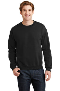 A person wearing a Gildan Heavy Blend Crewneck Sweatshirt 18000, crafted from a comfortable 50/50 cotton-poly blend, smiles against a white background, paired with classic jeans.