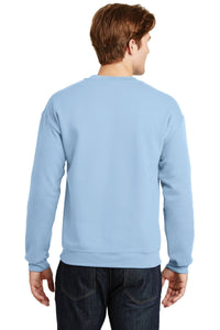 A man in a light blue Gildan Heavy Blend Crewneck Sweatshirt 18000 and dark jeans stands with his back to the camera, highlighting the classic 50/50 cotton poly blend fabric.