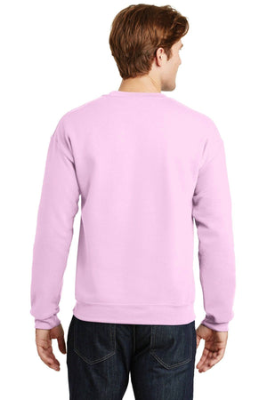 A person in a light pink Gildan Heavy Blend Crewneck Sweatshirt 18000 and blue jeans is shown from behind.