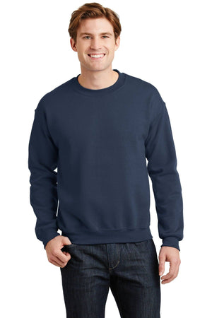 Dressed in a Gildan Heavy Blend Crewneck Sweatshirt 18000 and jeans, a person beams against a plain backdrop.