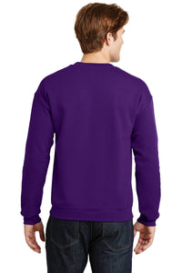 A person with brown hair is wearing a Gildan Heavy Blend Crewneck Sweatshirt 18000 in purple along with dark jeans, facing away from the camera.