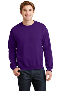 A person wearing a Gildan Heavy Blend Crewneck Sweatshirt 18000 in purple paired with dark jeans, standing and smiling.