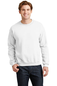 A person wearing a plain white Gildan Heavy Blend Crewneck Sweatshirt 18000 and dark jeans stands smiling.