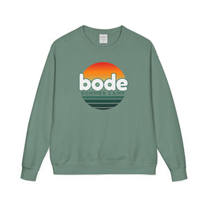The Printify 2026 Bode Summer Bootcamp Crewneck Sweatshirt (GDH400) is a green Hanes Comfortwash fleece with a vintage wash and DTF-printed sunset graphic and "bode SUMMER CAMP" text on the front.