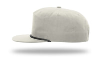 Side view of a light gray Richardson 256 Umpqua Rope Snapback Cap with black trim near the brim, set against a white background with the cap appearing to float.