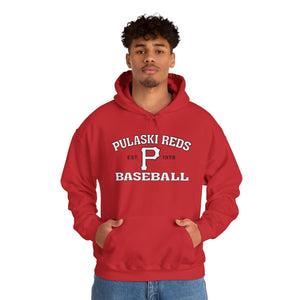 A person wearing a Printify Pulaski Reds Baseball Est. 1978 Unisex Heavy Blend™ Hooded Sweatshirt, featuring a bold red design with a large "P" on the front.