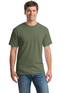 A man faces forward, smiling, wearing a Gildan Heavy 100% Cotton Custom T-Shirt (Gildan 5000) in plain olive green and blue jeans against a white background.