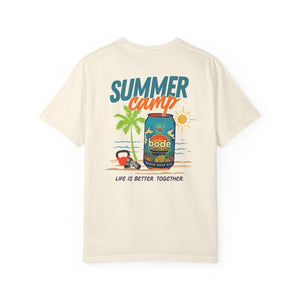 The Printify Summer Camp T-Shirt features a cream color and a beach can design with palm trees, sun, campfire, and “Life is better. Together.” text for a relaxed summer vibe.