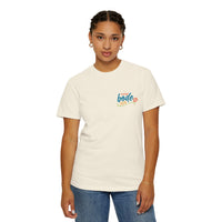 A person faces forward wearing the Printify BODE Summer Camp T-Shirt 2026—"Life's Better Together" (Unisex Comfort Colors 1717)—with a small orange graphic on the left chest, paired with blue jeans.