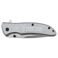The Bison River Custom Laser Engraved 4 1/4" Everyday Carry Knife features a silver handle, custom-engraved with "Barbaro Tuning & Performance" and a car outline—perfect for corporate gifts or promotional giveaways.