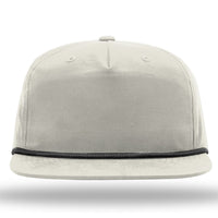 Front view of a light gray Richardson 256 Umpqua Rope Snapback Cap with black cord detail above the brim, featuring UPF 50+ protection, set against a white background.
