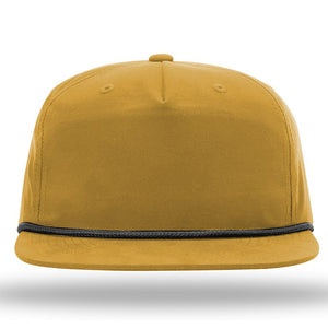 A Richardson 256 Umpqua Rope Snapback Cap in mustard yellow, featuring a flat brim and black trim around the base, stands out in the image and offers UPF 50+ sun protection.