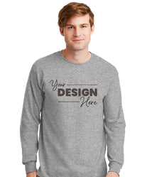 A man wears a Gildan 100% US Cotton Long Sleeve T-Shirt (Pack of 36), custom screen printed with "Your Design Here" in black on the front.