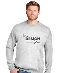 A man wearing a Hanes Ultimate 100% Cotton Crewneck Sweatshirt F260 in light gray, featuring the text "Your Design Here" on the front, stands against a plain white background. Ideal for anyone looking to order customizable Hanes crewneck sweatshirts in bulk.