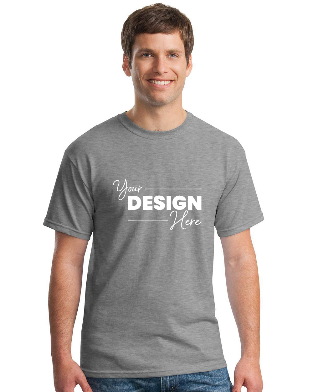 A man wears a Gildan Heavy 100% Cotton Custom T-Shirt (Gildan 5000), plain grey, with "Your Design Here" printed in white on the front.