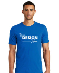 A person wearing a Nike Dri-FIT Cotton/Poly T-Shirt (NKBQ5231) in blue with the text "Your Design Here" printed in white.
