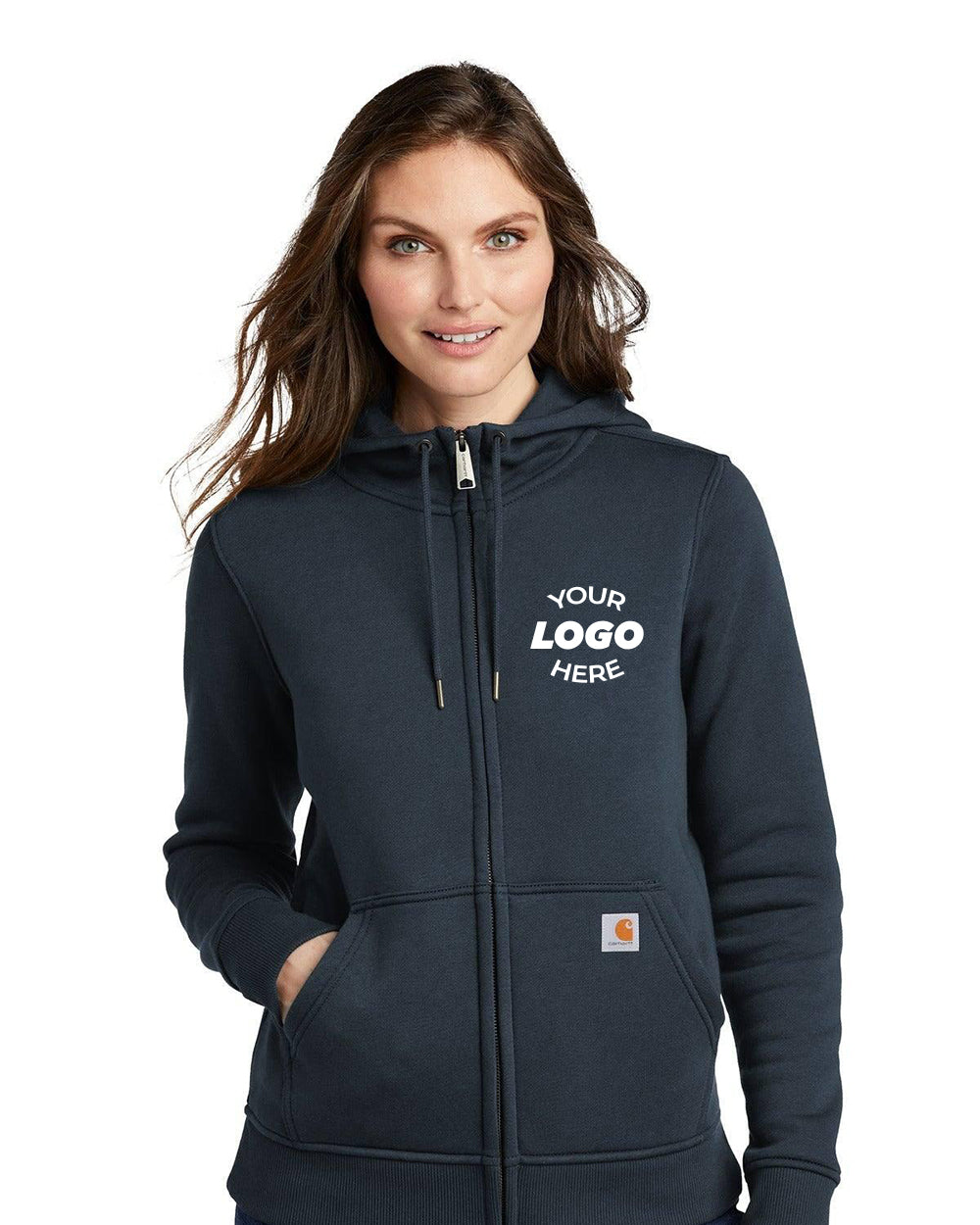 A woman wears the Carhartt Women's Clarksburg Full-Zip Hoodie Sweatshirt (CT102788) with "Your Logo Here" on the left chest, standing with hands in front pockets. This Carhartt hoodie blends comfort and style for everyday use.