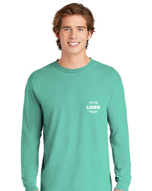 A young man wears a teal Comfort Colors Heavyweight Ring Spun Long Sleeve T-Shirt 6014, customized with "YOUR LOGO HERE" in white on the upper left chest.