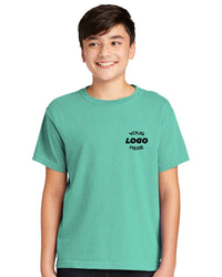 A youth wears a teal Comfort Colors Youth Ring Spun T-Shirt 9018, made of soft cotton and featuring "YOUR LOGO HERE," against a white backdrop.