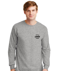 A man wears a Gildan (Pack of 36) 100% US Cotton Long Sleeve T-Shirt 2400, with a custom screen printed logo on the left chest—ideal for bulk orders of personalized shirts.