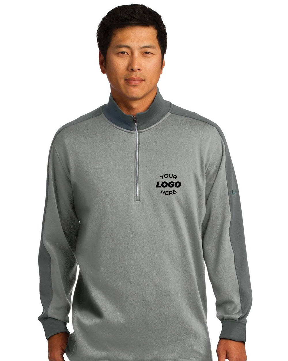 A man faces forward wearing a gray Nike Dri-FIT 1/2-Zip Pullover 578673 with "YOUR LOGO HERE" printed on it, designed for optimal moisture management.