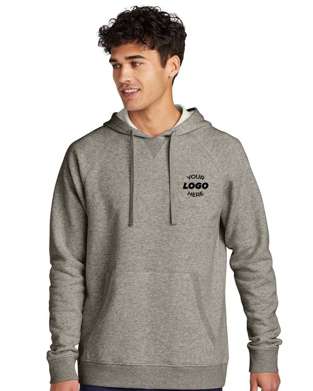 A young man wears the Sport-Tek Drive Fleece Pullover Hoodie Sweatshirt STF200, featuring a "Your Logo Here" design across the chest, showcasing its customizable appeal.