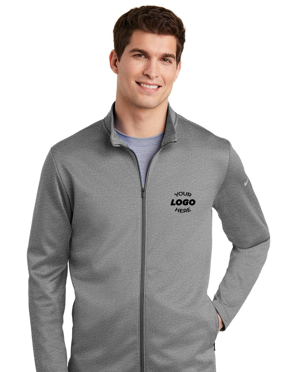 Someone is wearing a customizable gray Nike Therma-FIT Full-Zip Fleece NKAH6418 jacket featuring "Your Logo Here" on the chest.