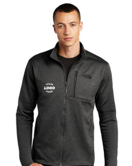 A man wearing a dark The North Face Skyline Full-Zip Fleece Jacket NF0A47F5, featuring technical stretch fleece and a logo on the left chest made from recycled polyester.