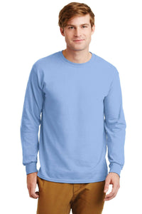 A man faces the camera in a light blue Gildan 100% US Cotton Long Sleeve T-Shirt (Pack of 36, style 2400, custom screen printed logo included) and brown pants, set against a plain background.