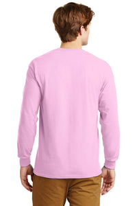 A man stands facing away, arms relaxed by his sides, wearing a light pink Gildan 100% US cotton long sleeve T-shirt (Pack of 36, style 2400, custom screen printed logo included) and tan pants.