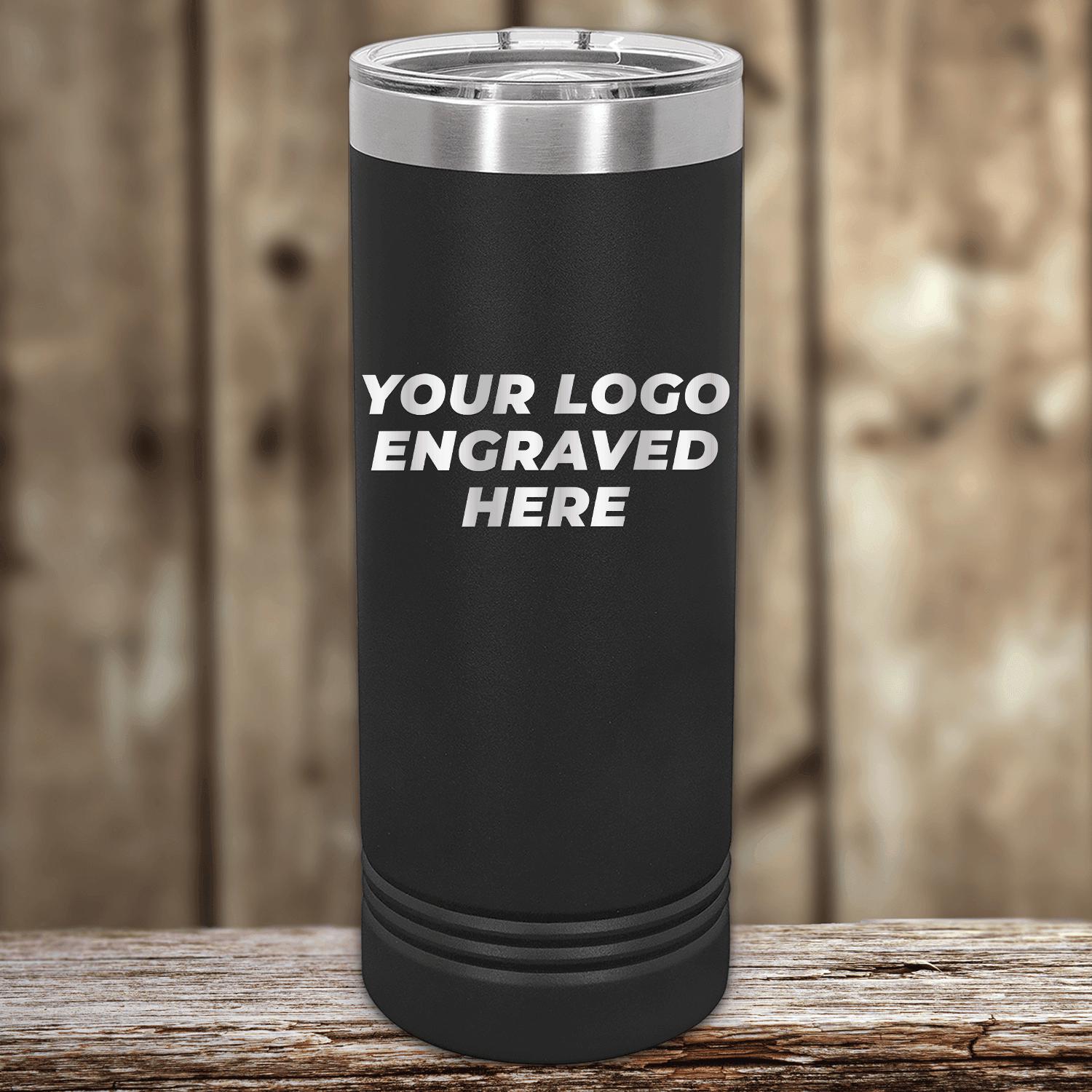 Black Custom Logo 22 oz Skinny Tumbler - Front side Logo Included, resting on a wooden surface against a blurred background. (Brand: Kodiak Coolers)