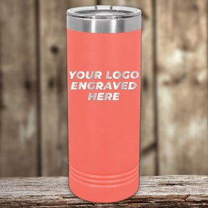 Coral pink insulated Custom Logo 22 oz Skinny Tumbler by Kodiak Coolers on a wooden surface, with a blurred background.