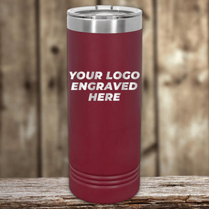A red insulated Custom Logo 22 oz Skinny Tumbler with "your custom logo here" text on a wooden surface against a blurred wooden backdrop by Kodiak Coolers.