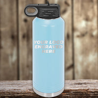 A light blue Kodiak Coolers insulated water bottle with a black lid sits on wood, featuring your custom engraved logo—perfect to match with engraved can holders. 4th of July SALE: Front logo included, $200 minimum order.