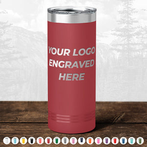 A Kodiak Coolers red stainless steel tumbler with "YOUR LOGO ENGRAVED HERE" on the front is displayed on wood—ideal for promotional gifts. Customize your drinkware; other color options available. BLACK FRIDAY SALE—no setup fee!.