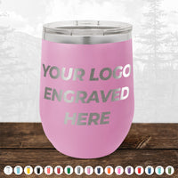 A pink 12 oz NO MINIMAL ORDER Kodiak Coolers wine cup, custom engraved with your logo in silver, sits on a wooden surface; multiple color options are displayed below—ideal for stylish personalized drinkware.