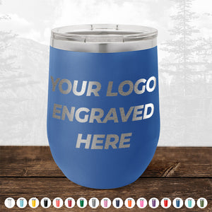 A blue Kodiak Coolers 12 oz stemless wine cup with a metallic lid sits on wood, displaying "YOUR LOGO ENGRAVED HERE." No minimum order—customize with your design. Various color options shown. Perfect for custom engraved mugs.