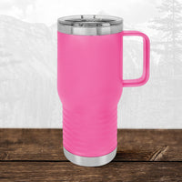 A Kodiak Coolers 20 oz Wisconsin Luxemburg Casco Spartans travel mug with handle and clear lid rests on wood, displaying its laser-engraved school design with a mountain backdrop.