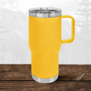 A Kodiak Coolers 20 oz travel mug with handle and clear lid, laser-engraved with Wisconsin Luxemburg Casco Spartans detailing, sits on a wooden surface against a mountain backdrop.