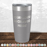 Kodiak Coolers Custom Tumblers—engrave your logo or design at no setup cost. Shown: silver tumbler on wood with forest backdrop. Ideal for promo gifts or personalized mugs; $200 minimum order. Multiple color options below.