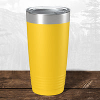 A Kodiak Coolers 20 oz tumbler with stainless steel lid features a laser-engraved Wisconsin Green Bay Bulldogs design, perfect for fans, displayed on wood with a mountain backdrop.