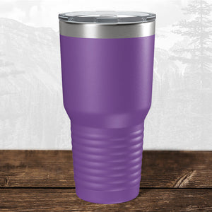 A 30 oz Kodiak Coolers tumbler with a laser-engraved Wisconsin Green Bay Bulldogs design and clear lid sits on wood with a mountain backdrop—ideal drinkware for Bulldogs fans.