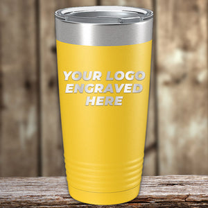 A yellow Kodiak Coolers Custom Tumblers 20 oz with your Logo or Design Engraved - Special Bulk Wholesale Pricing - Bundle Packs with a silver lid is placed on a wooden surface. The text "Your Logo Engraved Here" is laser engraved on the tumbler. The background is blurred with a wooden texture.